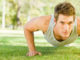 Physically fit man doing push-ups at the park