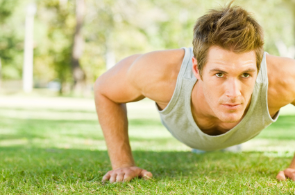 Physically fit man doing push-ups at the park